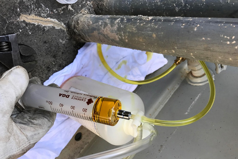 Technician performing transformer oil sampling and dissolved gas analysis (DGA)